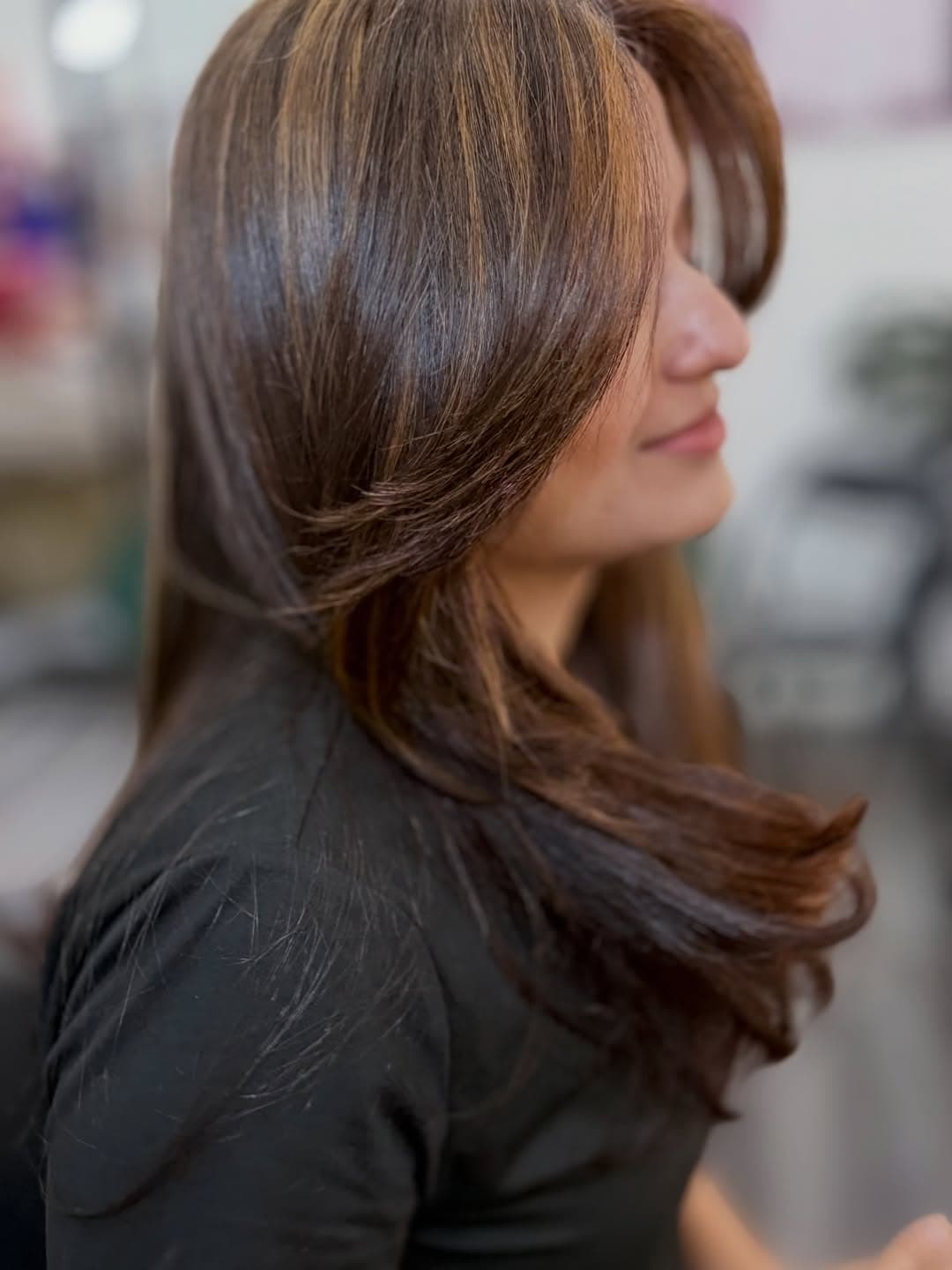 Close view of face-framing layers and warm brown colour